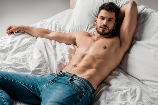 Bonito Sexy Sem Camisa Homem Jeans Deitado Cama Cinza — Fotografia de Stock