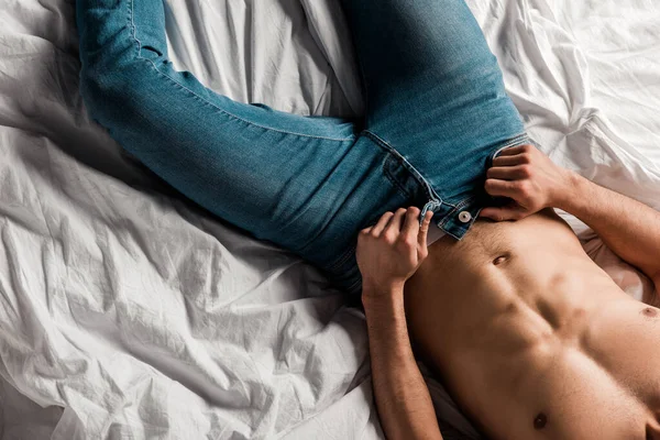 Beskärd Utsikt Över Skjortlös Sexig Man Tar Jeans Sängen — Stockfoto