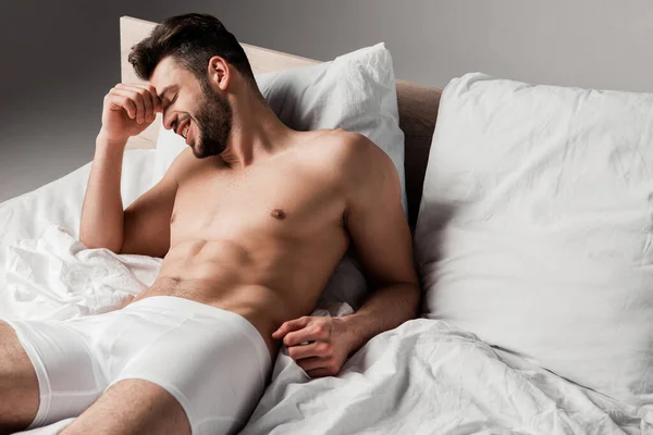 Lachender Schöner Sexy Mann Liegt Auf Bett Auf Grau — Stockfoto