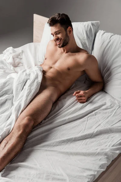 Cheerful Sexy Naked Man Lying Bed Grey — Stock Photo, Image