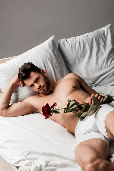 Bonito Sem Camisa Homem Deitado Cama Com Rosa Flor Isolado — Fotografia de Stock