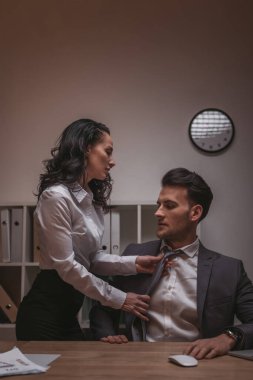 Güzel, baştan çıkarıcı sekreter resmi olarak yakışıklı iş adamının kravatını takıyor.