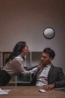 Yakışıklı Bsinessman 'ın kravatına dokunan çekici, şehvetli sekreter.