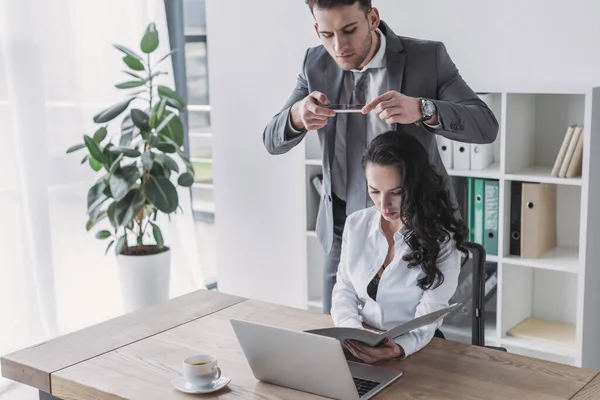 Stilig Affärsman Tar Foto Sekreterare Sitter Arbetsplatsen Knäppt Blus — Stockfoto