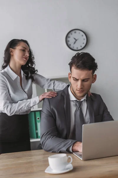 Sexy Sekretärin Berührt Schultern Eines Seriösen Geschäftsmannes Der Laptop Arbeitet — Stockfoto