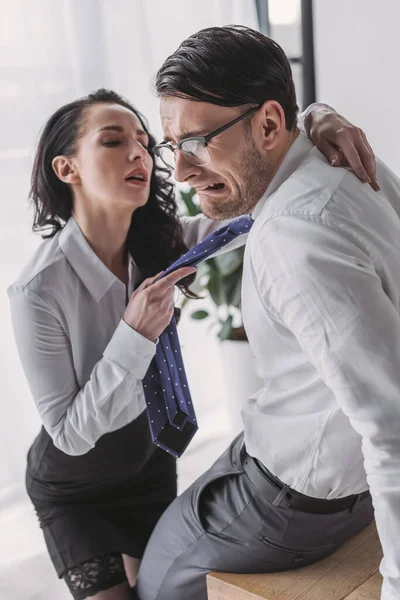 Sexy Secretaria Sosteniendo Corbata Abrazando Asustado Novio Mientras Seduce Oficina — Foto de Stock