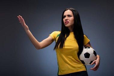 Gri top tutan kızgın bir futbol taraftarı.