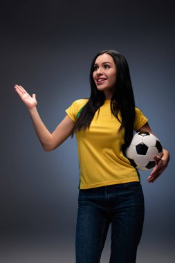 Güzel sürpriz futbol fanatiği gri topu tutuyor.