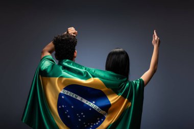 couple of football fans gesturing with brazil flag on grey clipart