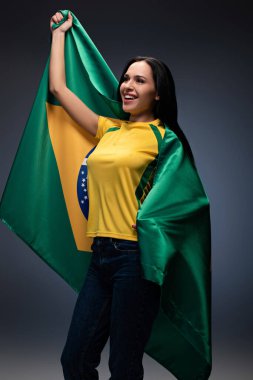Brezilya bayrağına sarılmış duygusal bayan futbol fanatiği.