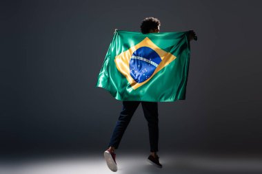football fan jumping with brazilian flag on grey clipart
