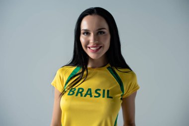 Sarı tişörtlü, gri tişörtlü, gülümseyen bayan futbol fanatiği. 