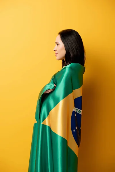 笑着的女足球迷 裹在黄色的巴西国旗上 — 图库照片