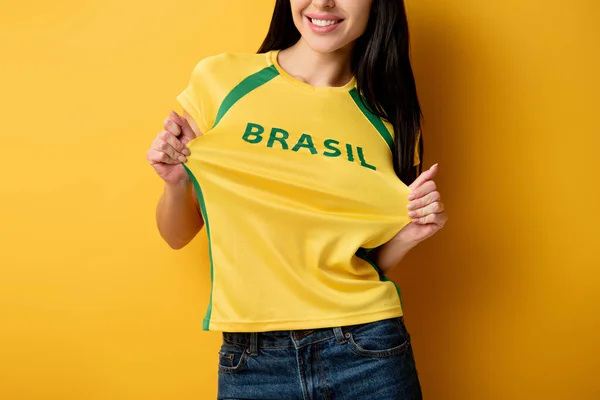 黄色のブラジルサイン付きの黄色のTシャツで幸せなサッカーファンのクロップドビュー — ストック写真