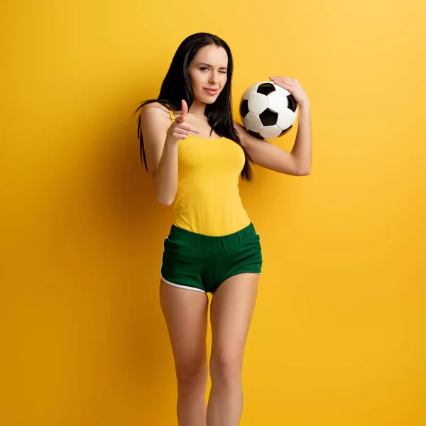 Happy Female Football Fan Ball Winking Pointing You Yellow — Stock Photo, Image