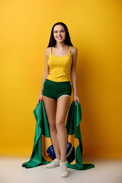 Sorridente Futebol Feminino Shorts Segurando Bandeira Brasileira Amarelo — Fotografia de Stock