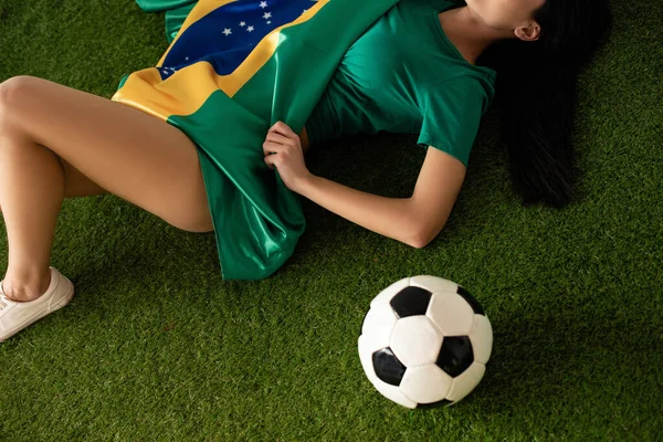 Oříznutý Pohled Sexy Ženu Ležící Fotbalovým Míčem Brazilskou Vlajkou Zelené — Stock fotografie