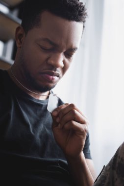Stresli bir Afro-Amerikan askeri, evinde askeri rozet taşıyor ve travma sonrası stres bozukluğu yaşıyor.