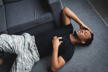 Stresli, asker rozetli Afro-Amerikan askeri evinde kalp krizi geçiriyor. Travma sonrası stres bozukluğu yaşıyor.  