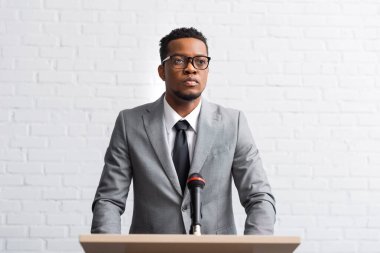 Afro-Amerikan iş adamı Tribün 'de konferans salonunda mikrofonlu bir konuşma yapacak.