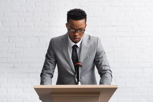 Konferans Salonunda Mikrofonlu Tribün Ciddi Bir Afro Amerikan Konuşmacısı — Stok fotoğraf