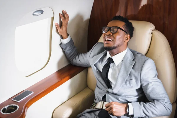 Afrikanisch Amerikanischer Geschäftsmann Mit Sicherheitsgurt Und Panikattacke Während Flug Privatflugzeug — Stockfoto