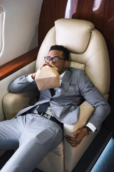 美国商人在私人飞机飞行过程中惊慌失措时 用纸袋呼吸 — 图库照片