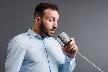 Sakallı adam gri teneke kutuyu tutarken aldı. 