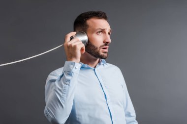 Kulağında teneke kutu tutan sakallı adam Griler 'de soyutlanmış insanları dinlerken 