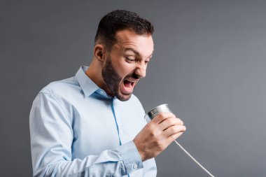 Kızgın adam ağarmış teneke kutuyu tutarken çığlık atıyor. 