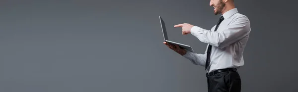 Panoramic Shot Businessman Suit Pointing Finger Laptop Isolated Grey — Stock Photo, Image