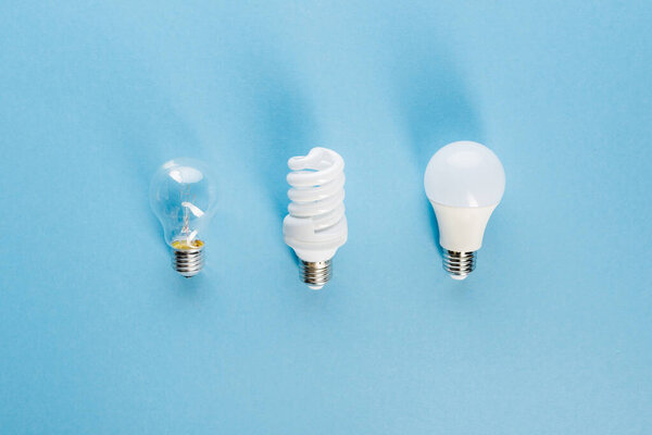 top view of different light bulbs on blue, evolution concept 