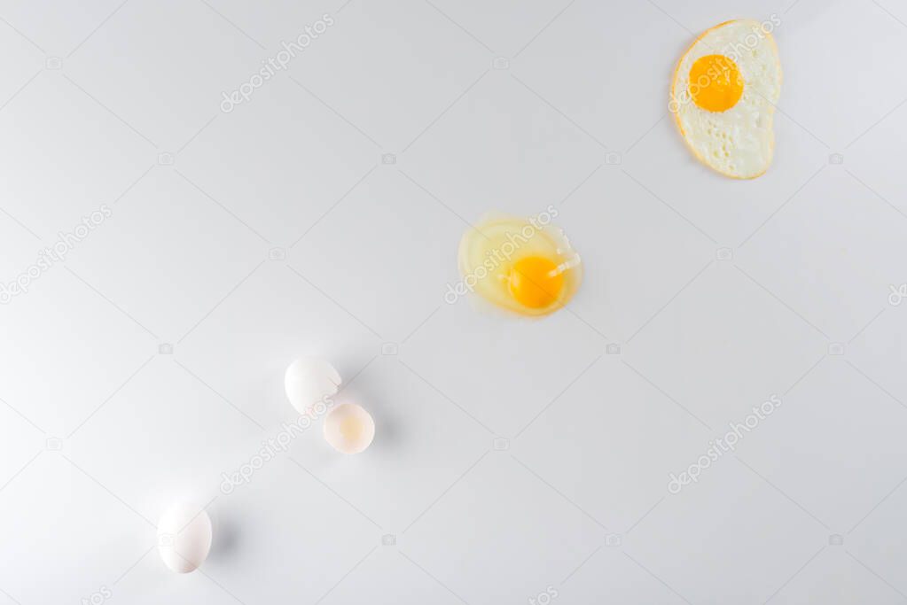 top view of eggs transformation phases from raw to fried on white 