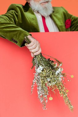 Son sınıf öğrencisinin, mercanlarda izole edilmiş kır çiçeği buketi tutarken çekilmiş görüntüsü. 