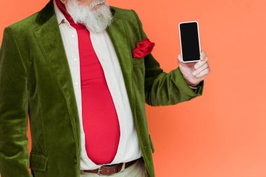 Mercan üzerinde izole edilmiş boş ekranlı akıllı telefon tutan şık bir son sınıf öğrencisi görüntüsü. 