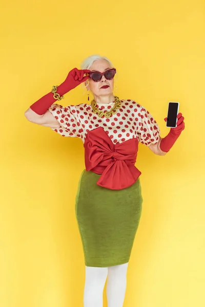 Stylish Senior Woman Sunglasses Holding Smartphone Yellow Background — Stock Photo, Image