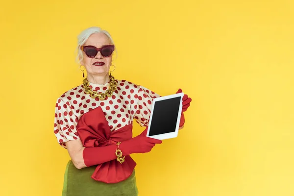 Mujer Mayor Moda Sonriendo Mientras Sostiene Tableta Digital Aislada Amarillo — Foto de Stock