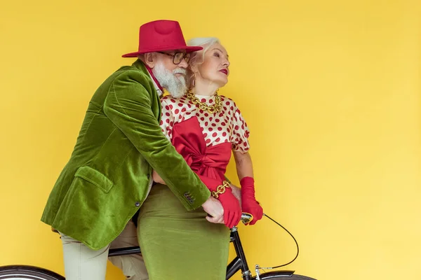 Casal Sênior Elegante Olhando Para Longe Bicicleta Isolada Amarelo — Fotografia de Stock