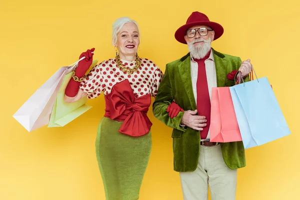 Stylish Senior Couple Shopping Bags Smiling Camera Yellow Background — Stock Photo, Image