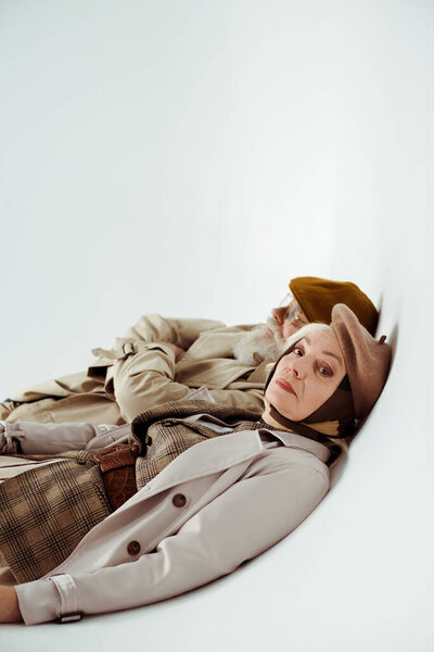 Вид сбоку стильной пожилой пары на белом фоне
