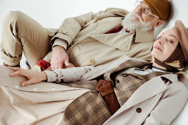 Elegante Senior Paar Trench Jassen Liggend Witte Achtergrond — Stockfoto