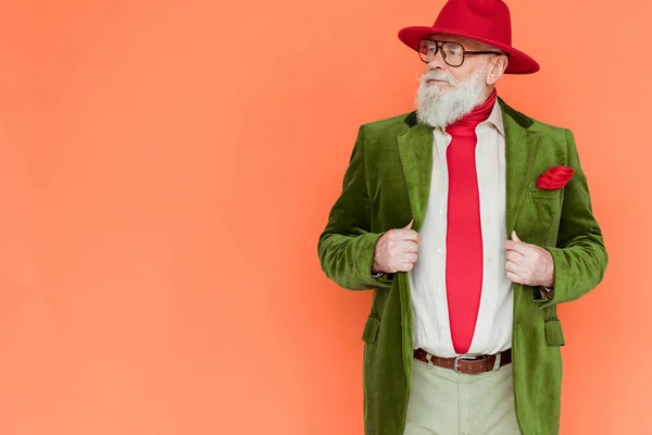 Handsome Senior Man Hat Holding Jacket Looking Away Isolated Coral — Stock Photo, Image