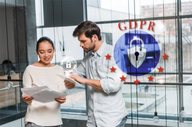 Genç yakışıklı iş adamı dijital tabletle çekici Asyalı meslektaşının yanında duruyor elinde belgeler, GDPR illüstrasyon