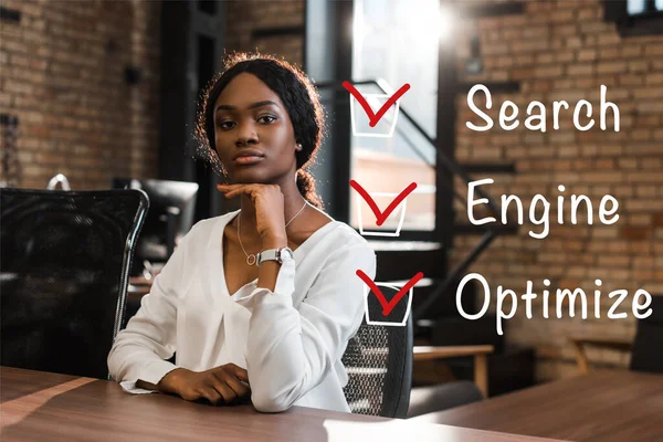 Attractive Thoughtful African American Businesswoman Sitting Desk Looking Camera Seo — Stock Photo, Image