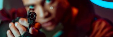 panoramic shot of gun in hands of bi-racial cyberpunk player  clipart