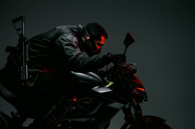 Gri üzerinde motosiklet süren maskeli iki ırklı siber punk oyuncusunun profili 
