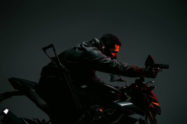 Silahlı, çift ırklı, maskeli, motosikletli, elinde gri bir silahla siber punk oyuncusunun profili. 