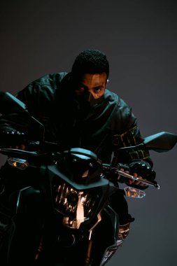 Gri üzerinde motosiklet süren maskeli yakışıklı karışık ırk siber punk oyuncusu. 