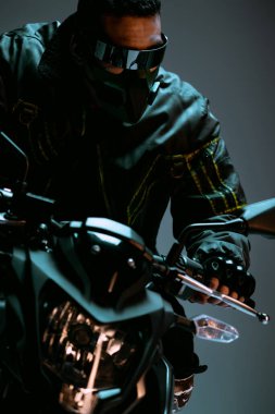 Maskeli karışık ırk siber punk oyuncusu ve gri renkli motosiklet süren fütüristik gözlüklü adam. 