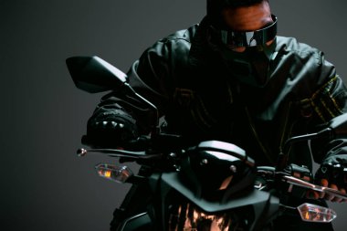 Maskeli, fütüristik gözlüklü, gri motosikletli çift ırklı siber punk adamın seçici odağı. 